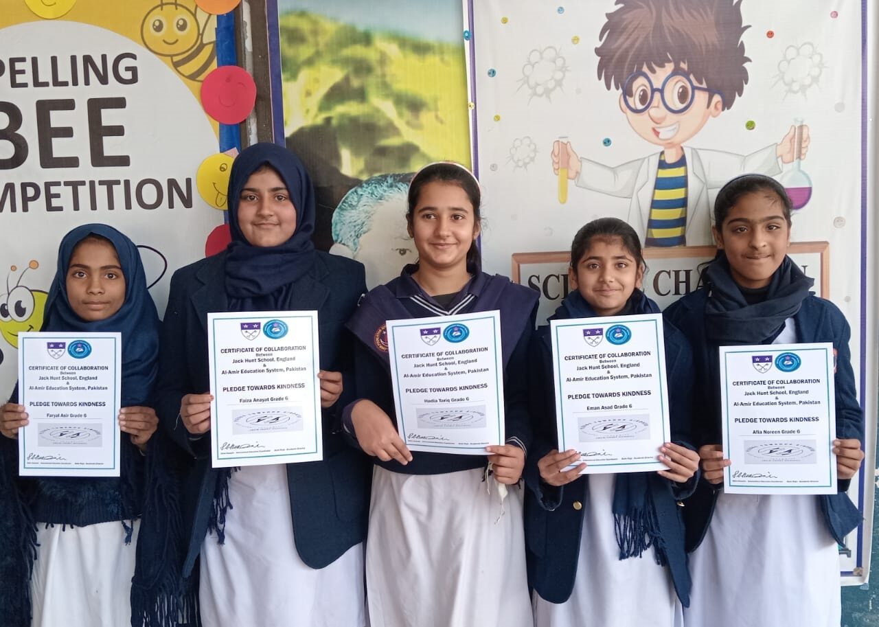 Students from Al Amir Education System in Pakistan stood holding certificates of collaboration for Pledge Towards Kindness